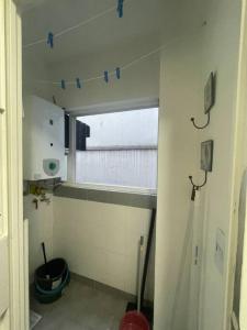布宜诺斯艾利斯Cómodo dos ambientes的一个小浴室,墙上有带蓝色胶带的窗户