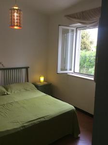 罗萨玛里纳Villa sul mare Rosa Marina的一间卧室设有一张床和一个窗口