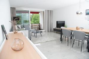 伦策海德Apartment La Riva 105 Lenzerheide with an indoor Pool的客厅配有桌椅和沙发