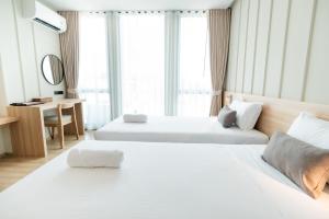 清迈Pillows boutique hotel的酒店客房配有两张床和一张书桌