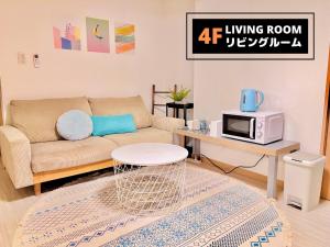 大阪Jen's House Osaka的带沙发和微波炉的客厅