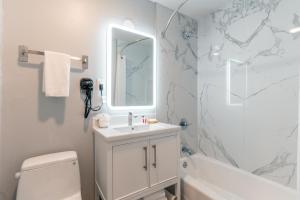 旧金山百老汇旅馆的白色的浴室设有水槽和镜子