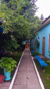 乔尔蓬阿塔гостевой дом "Бумеранг KG"的蓝色建筑前面的一条人行道,上面有蓝色长凳