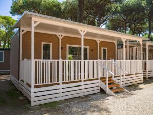 玛里纳罗米亚Sole Family Camping Village的一座带门廊和楼梯的小木房子