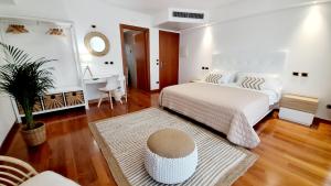 利尼亚诺萨比亚多罗弗拉伊皮尼酒店及健康中心的卧室配有一张白色的大床和一张桌子