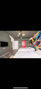 上海上海80逅创意民宿的一间卧室配有一张白色大床和色彩缤纷的床头板