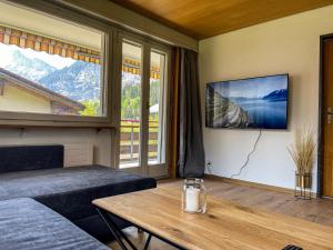 坎德施泰格Swiss Alps Lodge的客房设有床、桌子和大窗户。