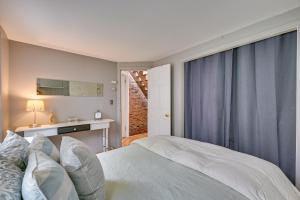 波士顿Cozy Boston Vacation Rental with Rooftop Deck!的卧室配有白色的床和窗户。