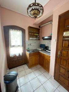 卡拉内拉Diamantoula Rooms的厨房设有木制橱柜、窗户和门。