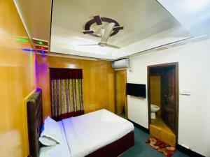 达卡HOTEL BLUE BIRD的客房设有一张床和一个吊扇。
