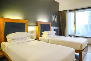 孟买克利须娜皇宫酒店的酒店客房设有两张床和窗户。