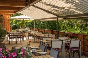 巴特维塞Hotel Villa Lago Garni的一个带桌椅和遮阳伞的餐厅庭院