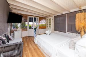 古穆斯卢克Vacation Flat w Garden Pool in Bodrum Gumusluk的一间卧室配有两张床和一台平面电视