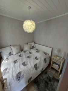 WaulsortLE PETIT CHALET - Bungalow的一间卧室配有一张床和一个吊灯