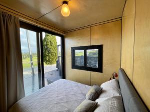 HangatikiWaitomo Retreat的一间卧室设有一张床和一个大窗户