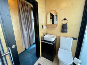HangatikiWaitomo Retreat的一间带卫生间、水槽和镜子的浴室