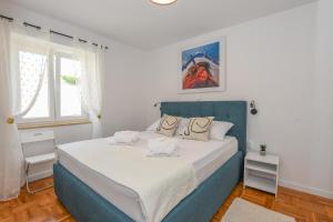 帕格Apartment Sidro的一间卧室配有一张大床和蓝色床头板