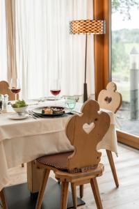 修希Dolmites Nature Hotel Vigilerhof的一张桌子,上面放着一盘食物和酒杯