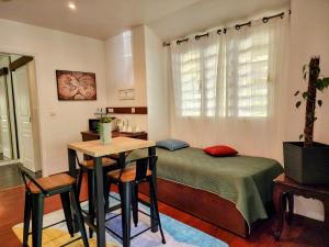 SarraméaEVASION Bungalow d'Antan Spa的卧室配有一张床和一张桌子及椅子