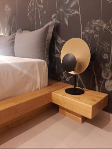 迈索隆吉翁Sroom Apartment的床头木桌边的灯