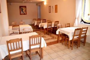 兹瓦尔东Fazolandia的用餐室配有白色的桌子和木椅