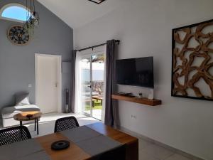 科斯塔特吉塞Bungalow La Palmera - 2 bedroom - PLAYA ROCA residence sea front access - Pool View - Free AC - Wifi的客厅配有桌子,墙上配有电视