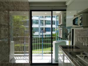 普吉镇2 Floor - Centrio Condominium near Central Shopping Mall and Phuket Old town的厨房设有滑动玻璃门,通往阳台