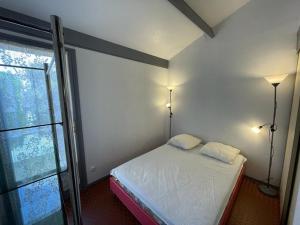 卡布勒通Maison Capbreton, 2 pièces, 4 personnes - FR-1-413-100的一间卧室配有一张带两盏灯的床和一扇窗户。