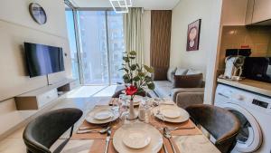 迪拜STAY BY LATINEM Luxury 1BR Holiday Home CVR A2803 near Burj Khalifa的客厅配有桌椅和电视