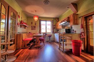 凯泽贝尔Appartements & Chambres Les Loges du Capucin的铺有木地板的厨房和桌子
