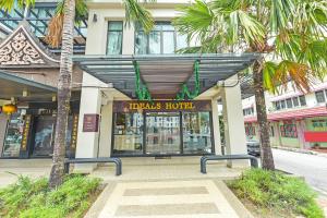 马六甲Ideals Hotel Melaka的一座楼前有棕榈树的商店