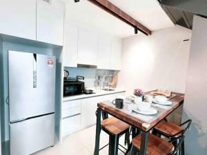 吉隆坡EkoCheras Cozy Suite by GUESTONIC的厨房配有桌椅和冰箱。