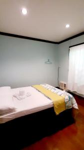 公主港Pinaluyan Guest House的一间卧室配有一张带黄色毯子的大床