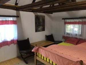Etno selo Krugerdorf的一间卧室配有两张床和一张桌子及椅子