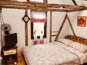 Etno selo Krugerdorf的卧室配有一张床,墙上挂着一个钟