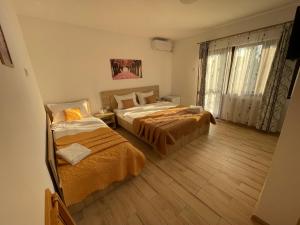 曼加利亚Vila Lorena的一间卧室设有两张床和窗户。