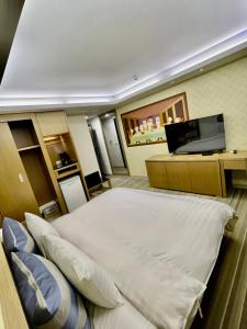 Changhua County晨阳文旅的客房设有一张床、一张桌子和一台笔记本电脑