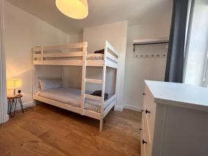 兰迪德诺Mona Lodge - 3 bed cottage in Llandudno的客房设有两张双层床和一张书桌。