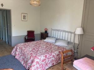 Les Tourellières的一间卧室配有一张床、一把椅子和一盏灯