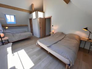 Hechtel-EkselDe Kamert的一间铺有木地板的客房内配有两张床的卧室