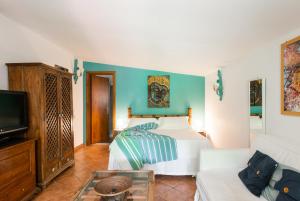 罗马阿皮亚安提卡旅馆的一间卧室配有一张床、一台电视和一张沙发