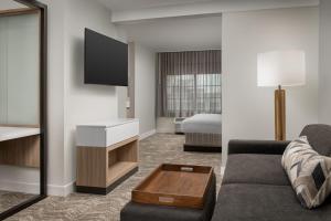 比福德SpringHill Suites by Marriott Atlanta Buford/Mall of Georgia的酒店客房设有一张沙发和一张床