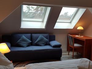 奥茨塞巴德·迪尔哈根Parkresidenz Dierhagen的客厅设有蓝色的沙发和2扇窗户。