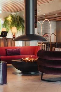 南泰利耶Ad Astra by Elite - Hotel, Spa & Resort的客厅中间的一个火坑,客厅里有一个沙发