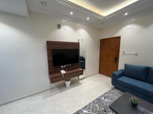 艾卜哈مساكن الراحة的客厅配有蓝色的沙发和平面电视。