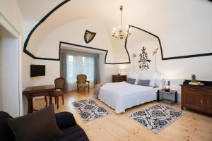 利普托夫堡大城堡酒庄酒店的卧室配有白色的床和桌椅