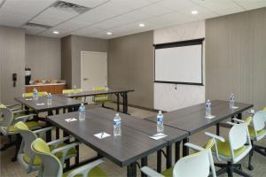 杰克逊维尔SpringHill Suites by Marriott Jacksonville Baymeadows的一间会议室,配有桌椅和白色屏幕