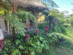 BaturitiLembah Cinta Mayungan的一个带长凳和一些植物和树木的花园