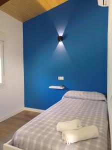 Hinojosa de San VicenteBungalow Sierra San Vicente的蓝色的墙壁,床上有两条毛巾