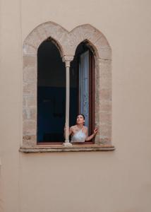 夏卡La Bifora e il granaio的女人从窗口看出来
